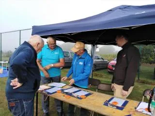 Deelnemers aan de inschrijvingstafel onder de tent