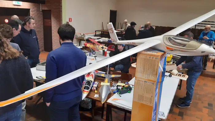 Overzicht van de zaal met zwevers langs de muur