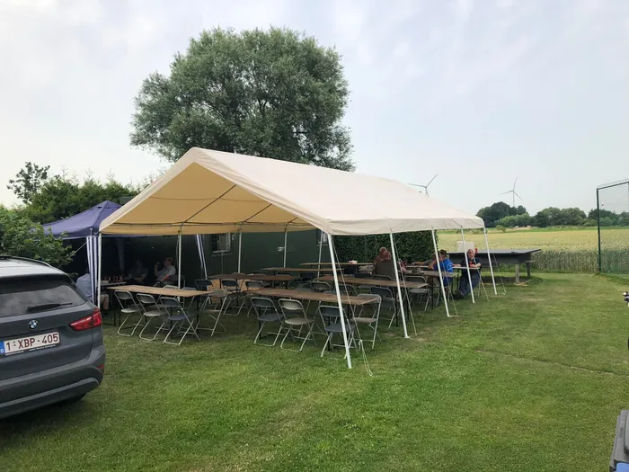 De pits met tent en wagens op het veld