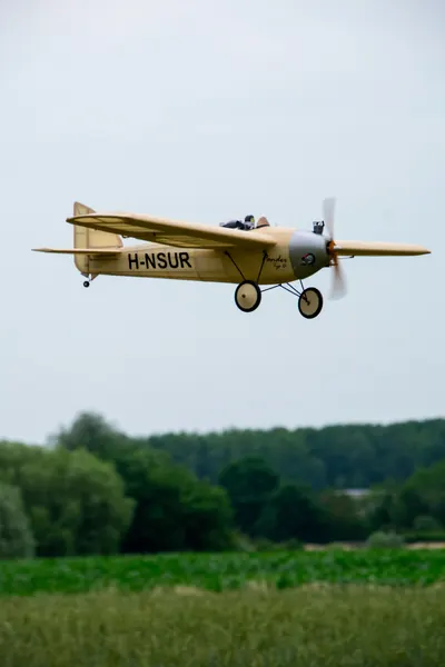 Vintage modelvliegtuig scheert laag over het veld